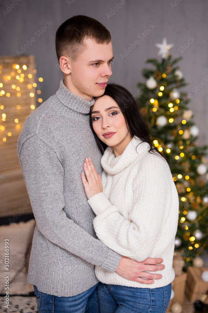 christmas, new year and love concept - young couple in love posing over Christmas background christmas, new year and love concept - young couple in love posing over Christmas background