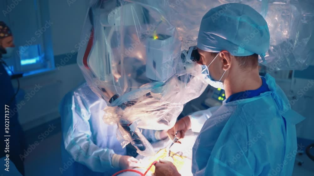 Shot of emergency and serious accident. Surgeons team working with monitoring of patient Shot of emergency and serious accident. Surgeons team working with monitoring of patient