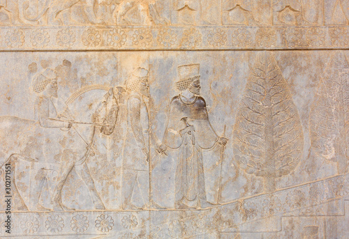 Image of assyrian warriors with spears in their hands. Ancient reliefs on the ruined walls of the Persepolis. Persepolis. Iran.