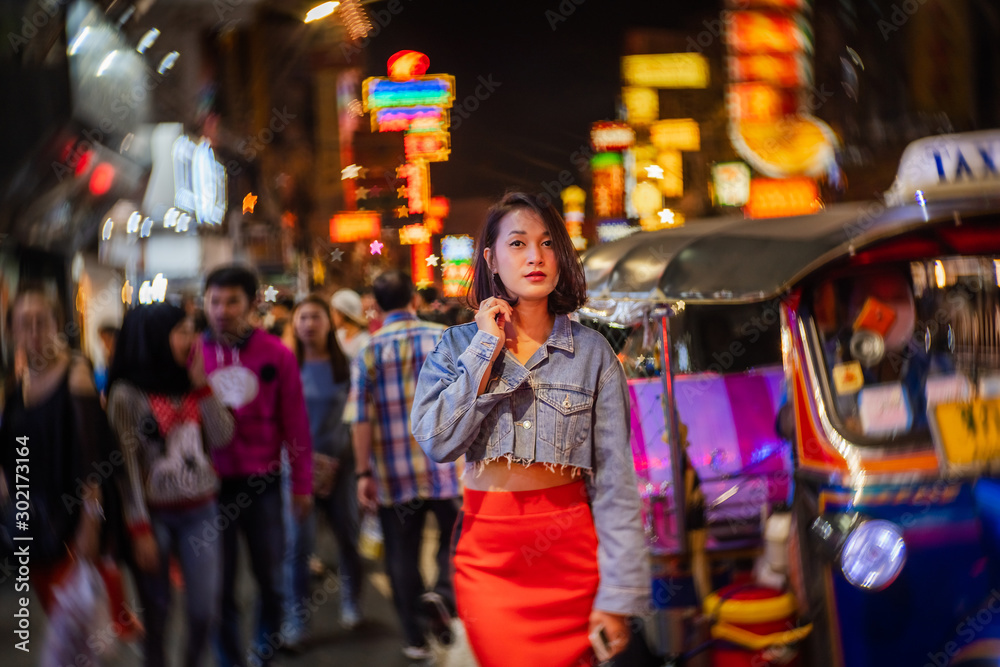 Young Asian fashion stylish traveler woman standing outdoor on street joy city nightlife in China town, Tourist girl travel Bangkok city Thailand, Tourism beautiful destination Asia holiday vacation