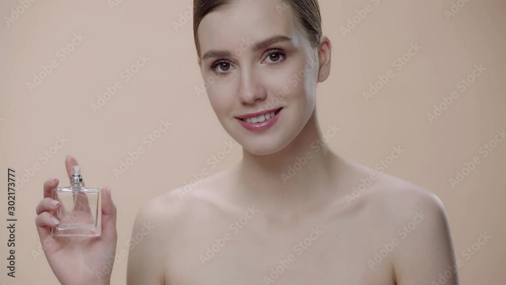 naked woman smelling perfume isolate don beige 