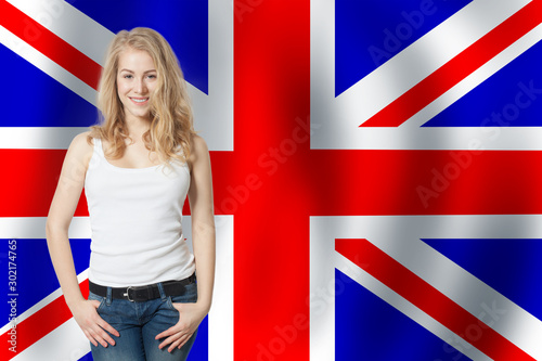 Portrait of happy pretty girl with the UK flag background. Young woman learning english language and traveling in United Kingdom