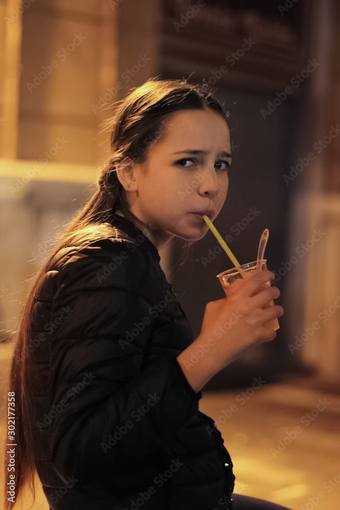 Fototapeta premium A beautiful girl drinking fresh juice
