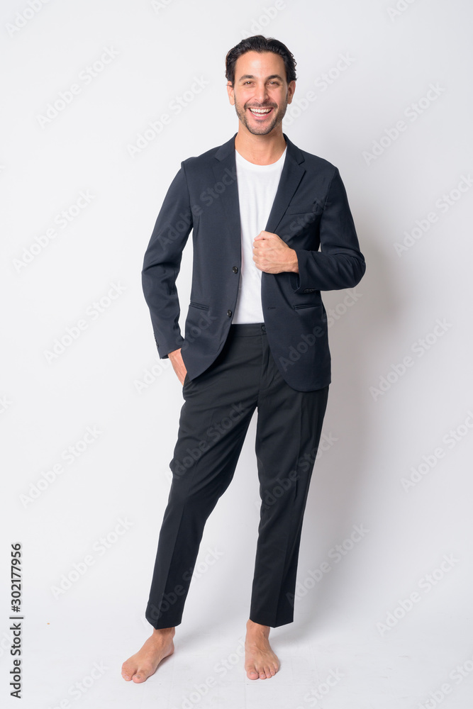 Full body shot of happy Hispanic businessman laughing Full body shot of happy Hispanic businessman laughing
