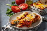 Spinach and ricotta stuffed cannelloni baked  in tomato sauce.