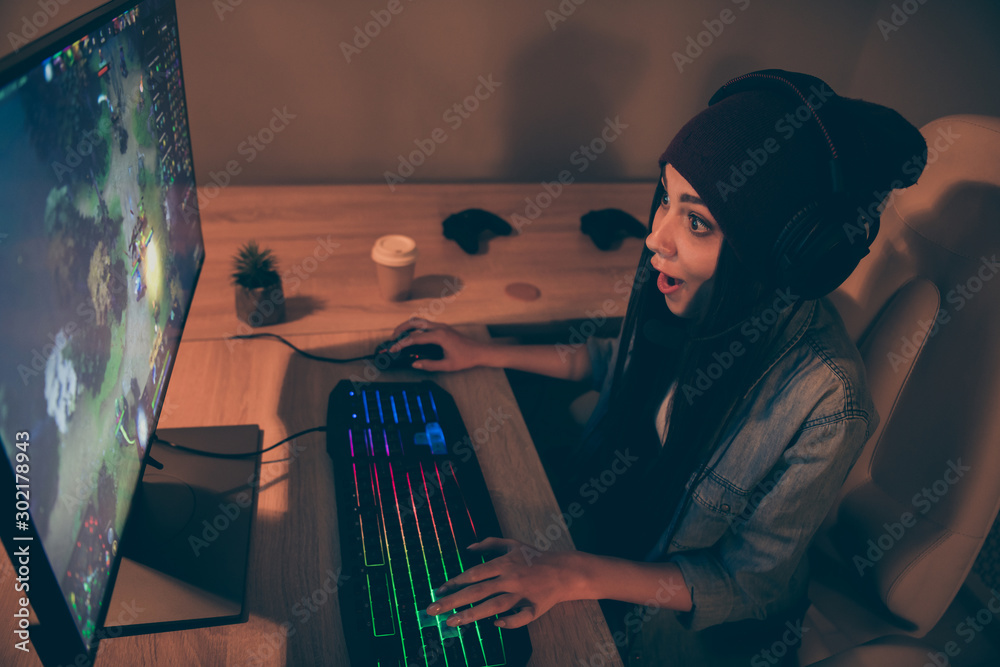 Top above high angle view photo of cheerful positive pretty sweet girl in cap headwear pressing keyboard with long brunette hair playing video game at night Top above high angle view photo of cheerful positive pretty sweet girl in cap headwear pressing keyboard with long brunette hair playing video game at night