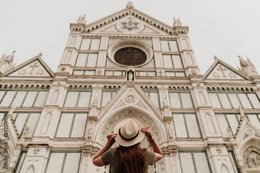 tourist girl in hat looks at Basilica di Santa Croce. Florence, Italy