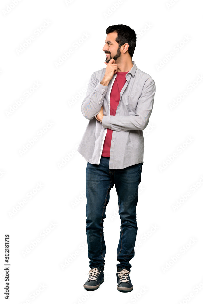 Full-length shot of Handsome man with beard looking to the side over isolated white background Full-length shot of Handsome man with beard looking to the side over isolated white background