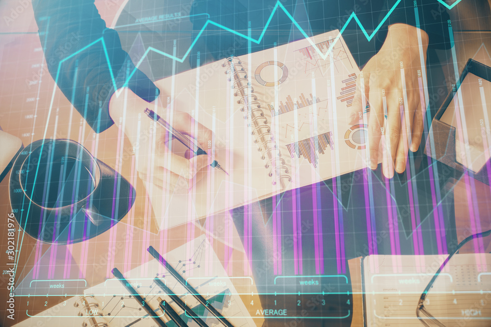 Double exposure of hands making notes with forex chart huds. Stock market concept. Double exposure of hands making notes with forex chart huds. Stock market concept.