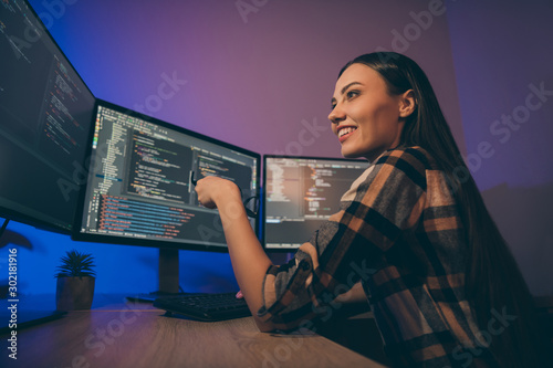 Profile side photo of cheerful positive nice pretty woman smiling toothily holding eye glasses sitting near screens looking through code written