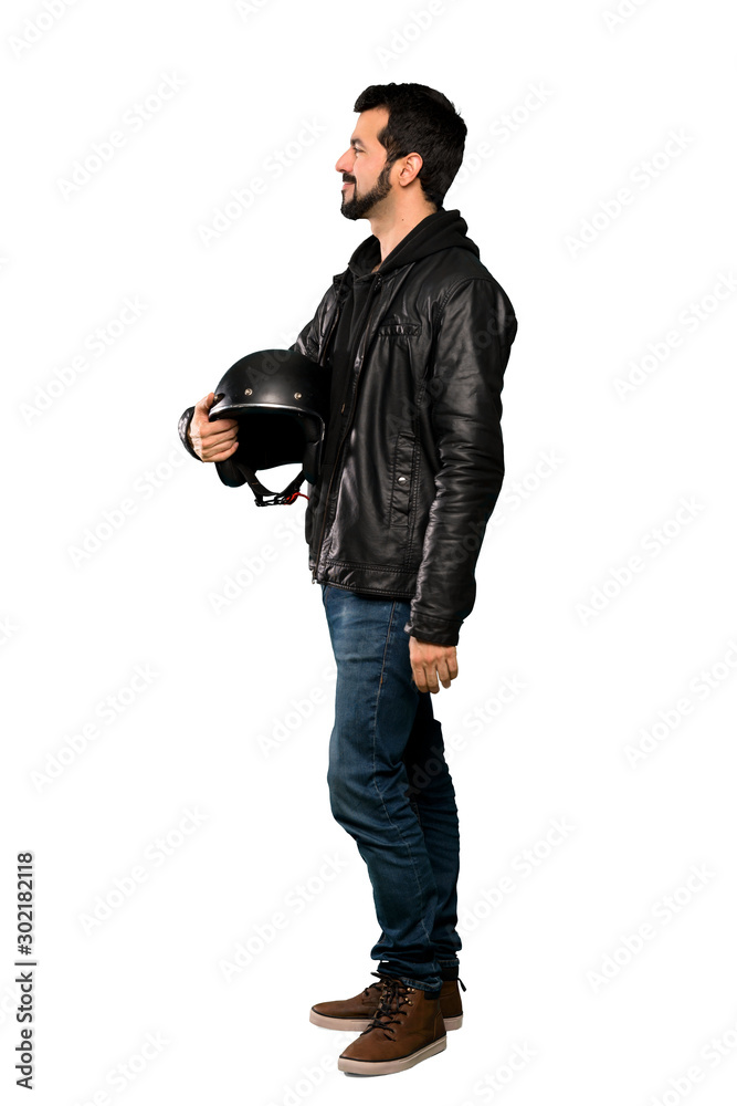 Full-length shot of Biker man in lateral position over isolated white background