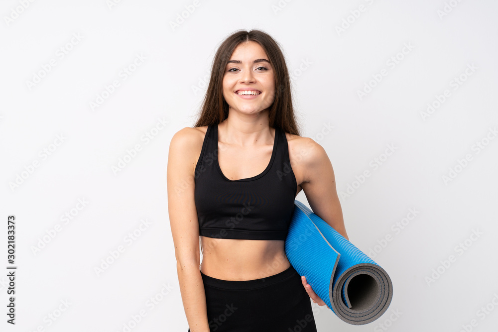 Young sport woman over isolated white background with a mat and smiling Young sport woman over isolated white background with a mat and smiling
