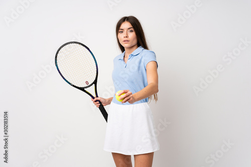 Young girl over isolated white wall playing tennis © luismolinero