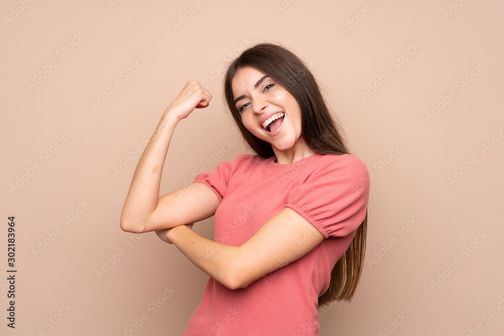 Young woman over isolated background making strong gesture Young woman over isolated background making strong gesture