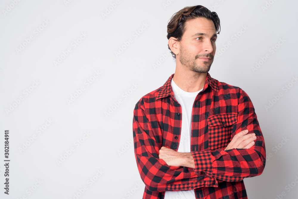 Portrait of handsome Hispanic hipster man thinking with arms crossed Portrait of handsome Hispanic hipster man thinking with arms crossed