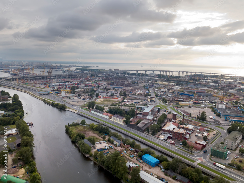 Drone view of the industrial part of St. Petersburg, Kanonersky island with Western high-speed diameter and the Gulf of Finland on the horizon