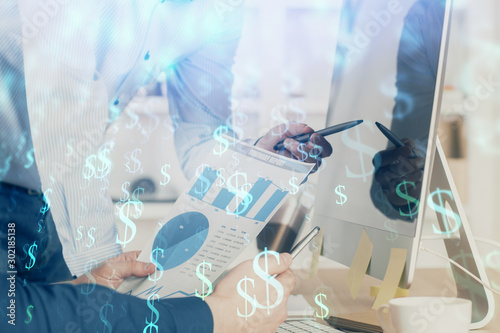 Double exposure of chart with businessman typing on computer in office on background. Concept of hard work.