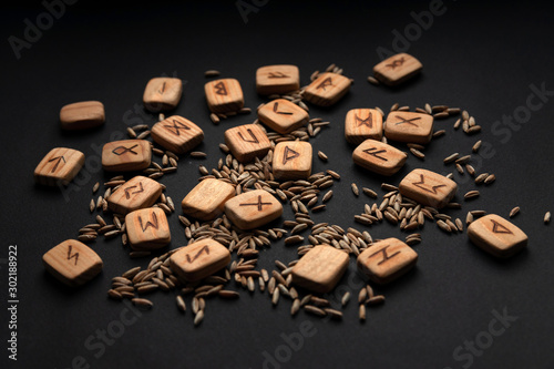 Scandinavian runes with rye on black background, histirical pagan symbols photo