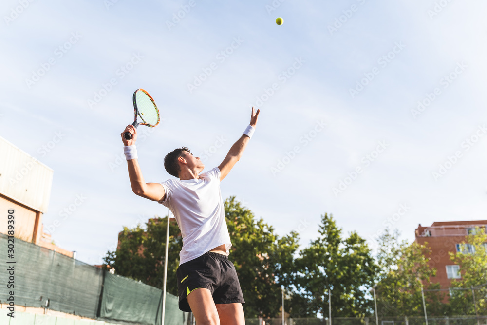 Young Man Playing Tennis Outdoors.