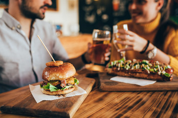 friends making a toast in bar, while eating fast food