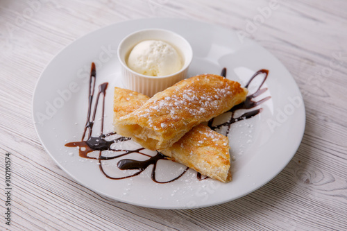 Classic apple strudel with a scoop of ice cream. restaurant menu dessert strudel