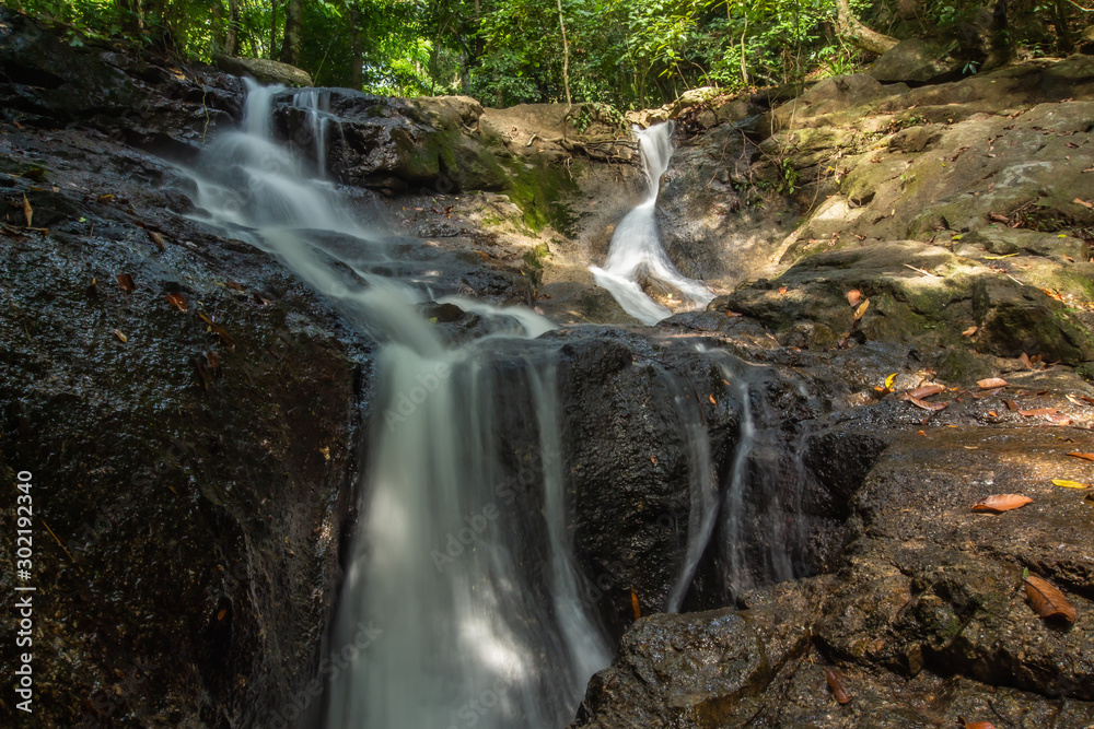 Fototapeta premium Kathu Waterfall in the tropical forest area In Asia, suitable for walks, nature walks and hiking, adventure photography Of the national park Phuket Thailand,Suitable for travel and leisure.