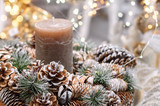 Christmas decoration with pine cones, fir branches, candle and Christmas lights. Close-up, selective focus.