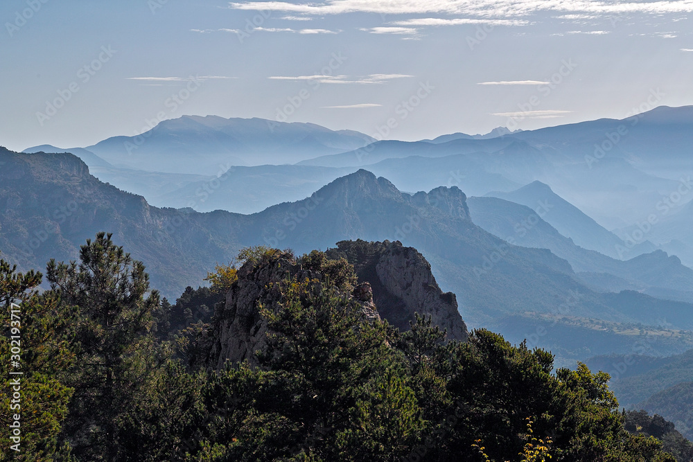 Panorama der spanischen Pyreneen mit bewaldeten Felsen im Vordergrund