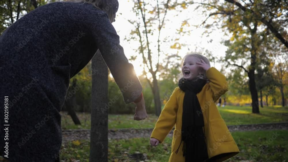 happy child, smiling little girl having fun with her mother in a game of stone scissor paper while walking in the autumn park happy child, smiling little girl having fun with her mother in a game of stone scissor paper while walking in the autumn park