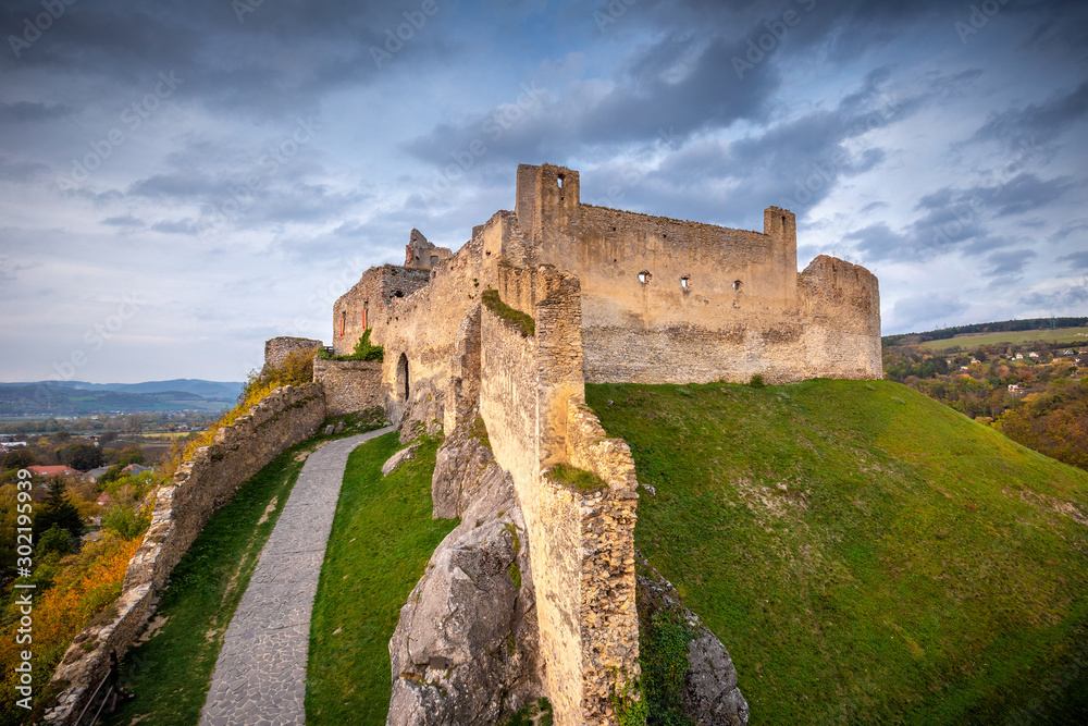 Medieval castle Beckov in autumn landscape at sunset, Slovakia, Europe.