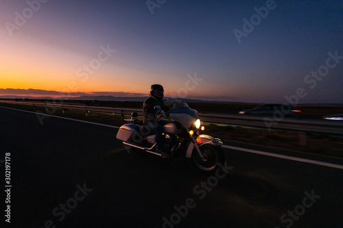 Burgas  Bulgaria - September 30.2019 Motorcyclists on    Honda Shadow driving on the asphalt road in rural landscape at sunset with dramatic clouds
