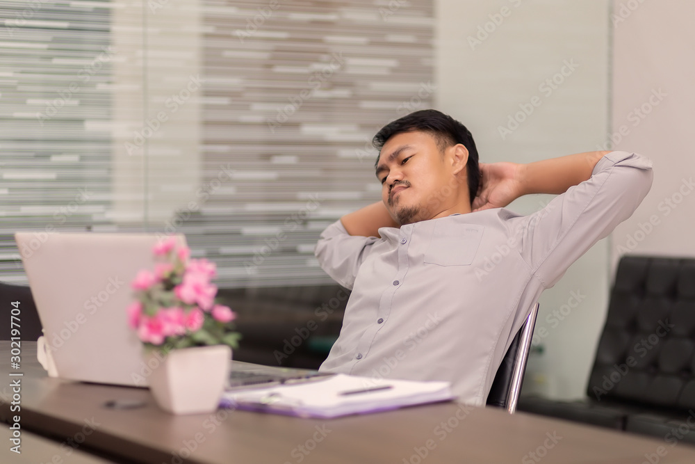Asian business people are feeling stressed about the job with laptop and paper on the wooden table in the office. Asian men are worried when their work is unsuccessful. Asian business people are feeling stressed about the job with laptop and paper on the wooden table in the office. Asian men are worried when their work is unsuccessful.