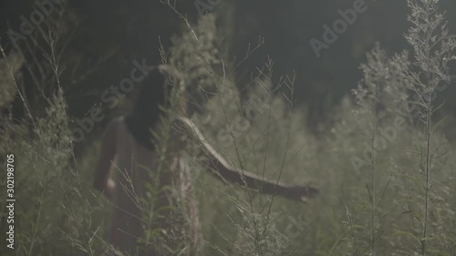 young woman walking through the valley. Hands touching high grass S-log, ungraded photo