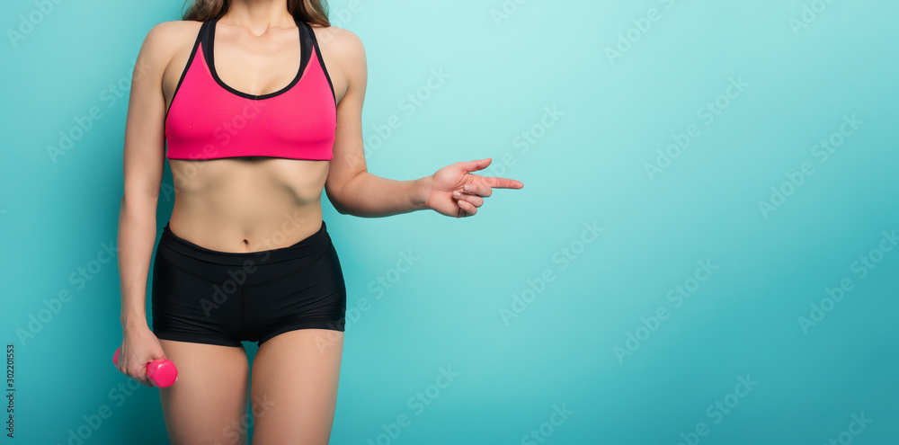 Gymnastic girl indicates something. concept of health and physical fitness . Cyan background Gymnastic girl indicates something. concept of health and physical fitness . Cyan background
