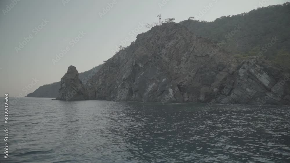 Pznoramic view of an island cliff from boat in the sea, s-log ungraded