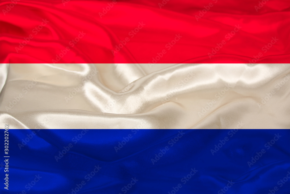 beautiful photo of the colored national flag of the modern state of the Netherlands on textural fabric, concept of tourism, emigration, economics and politics, closeup beautiful photo of the colored national flag of the modern state of the Netherlands on textural fabric, concept of tourism, emigration, economics and politics, closeup