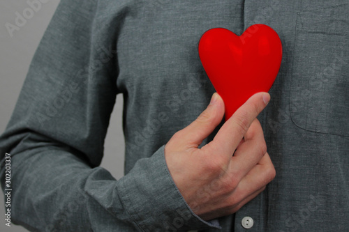 Konstfotografi guy holds a red heart model in his hand in his hand, as a symbol of a declaratio