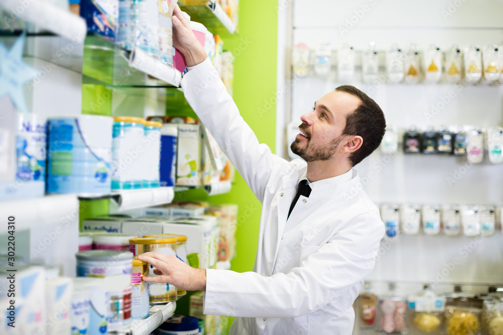 Smiling man pharmacist browsing preparation
