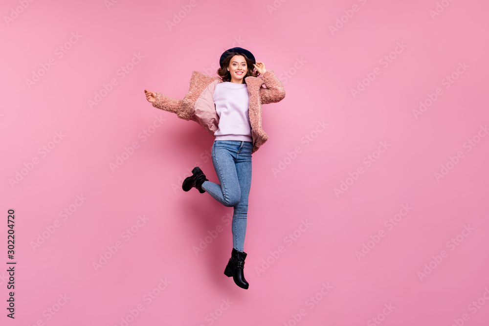 Full body photo of amazing funny model millennial lady jumping high tourist abroad rejoicing wear stylish fluffy jacket retro hat jeans boots isolated pink background