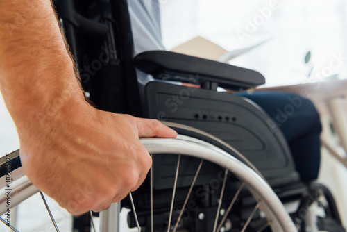 Close up of man holding wheel of wheelchair