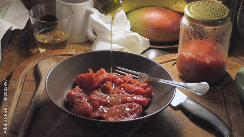 chef adds extra virgin olive oil to the tomato sauce in a dish chef adds extra virgin olive oil to the tomato sauce in a dish