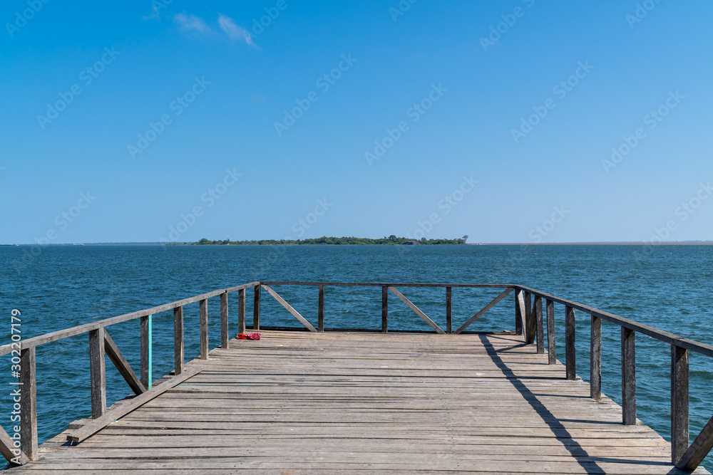 Wooden pier bridge on sunny summer day in amazon with beautiful waters of Tapajos River in the city of Santarem, Para, Brazil.Travel, tourism, wanderlust, climate change and conservation concept.