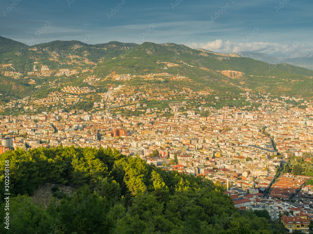 Alanya, Turkey. Beautiful view from the fortress Alanya Castle of the city Alanya at sunset on a background of mountains. Vacation postcard background