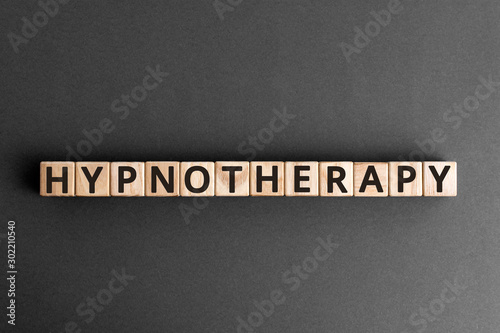 Hypnotherapy - word from wooden blocks with letters, therapy under hypnosis hypnotherapy concept,  top view on grey background photo