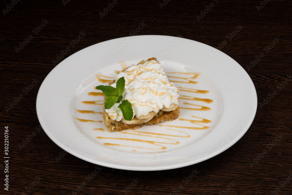 banana nut cake with cream on a white plate