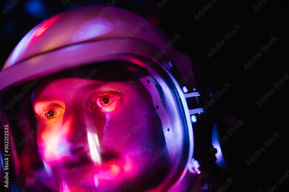 Astrounaut man in a helmet looking ahead exploring the earth in a dark