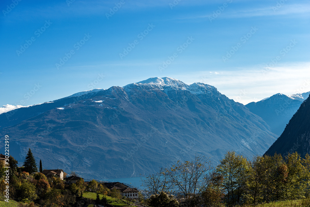 Fototapeta premium Lake Garda and Monte Baldo with snow in autumn, Italian Alps near Riva del Garda, photographed from the medieval village of Canale di Tenno, Trento province, Trentino-Alto Adige, Italy, Europe 
