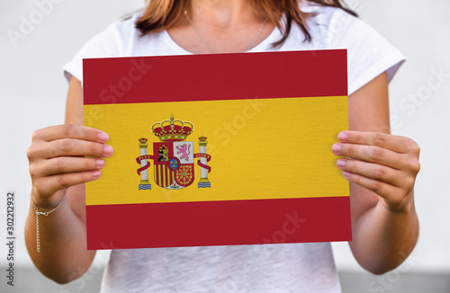 woman holds flag of Spain on paper sheet