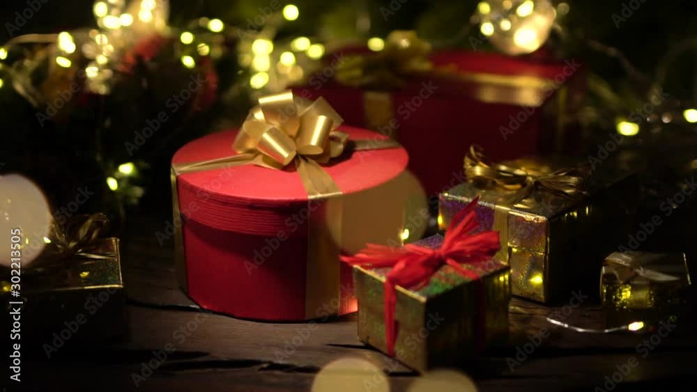Christmas background with red gift boxes. Сamera slowly approaches the gift, in the foreground and background is beautiful bokeh with Christmas lights. Christmas background with red gift boxes. Сamera slowly approaches the gift, in the foreground and background is beautiful bokeh with Christmas lights.