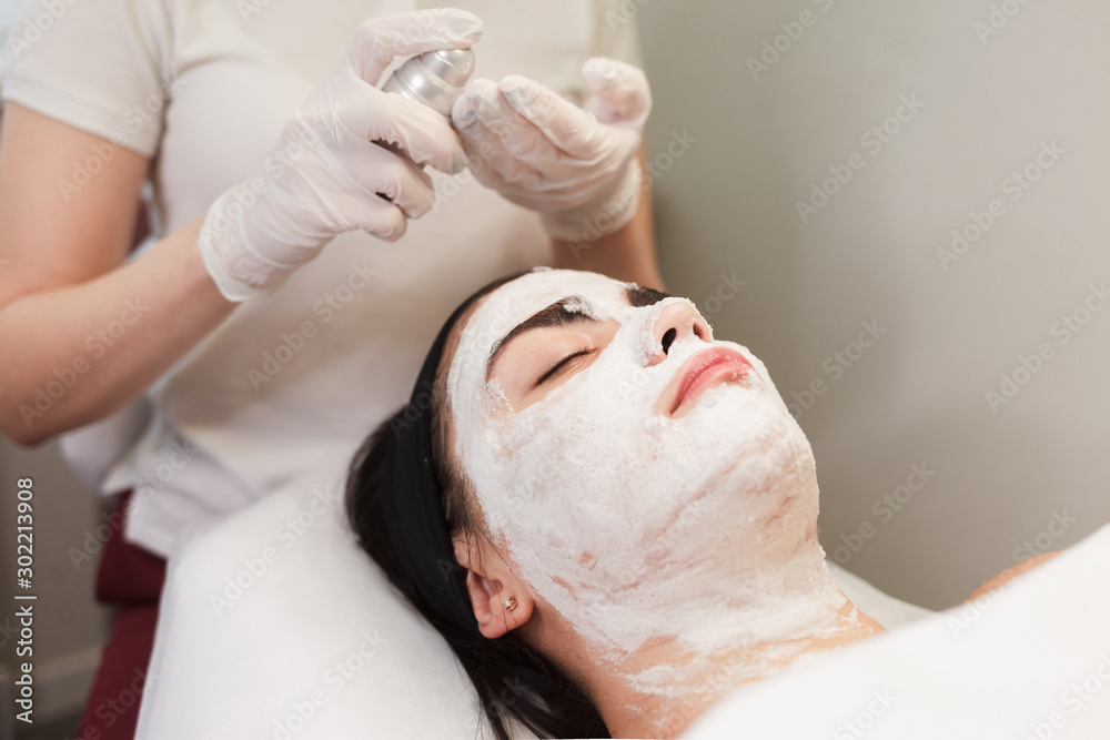 Cosmetologist applies foam on the face of a girl Cosmetologist applies foam on the face of a girl
